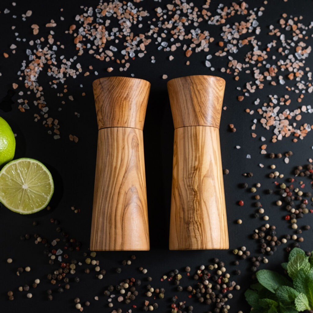 Two wooden salt and pepper mills on a black background.