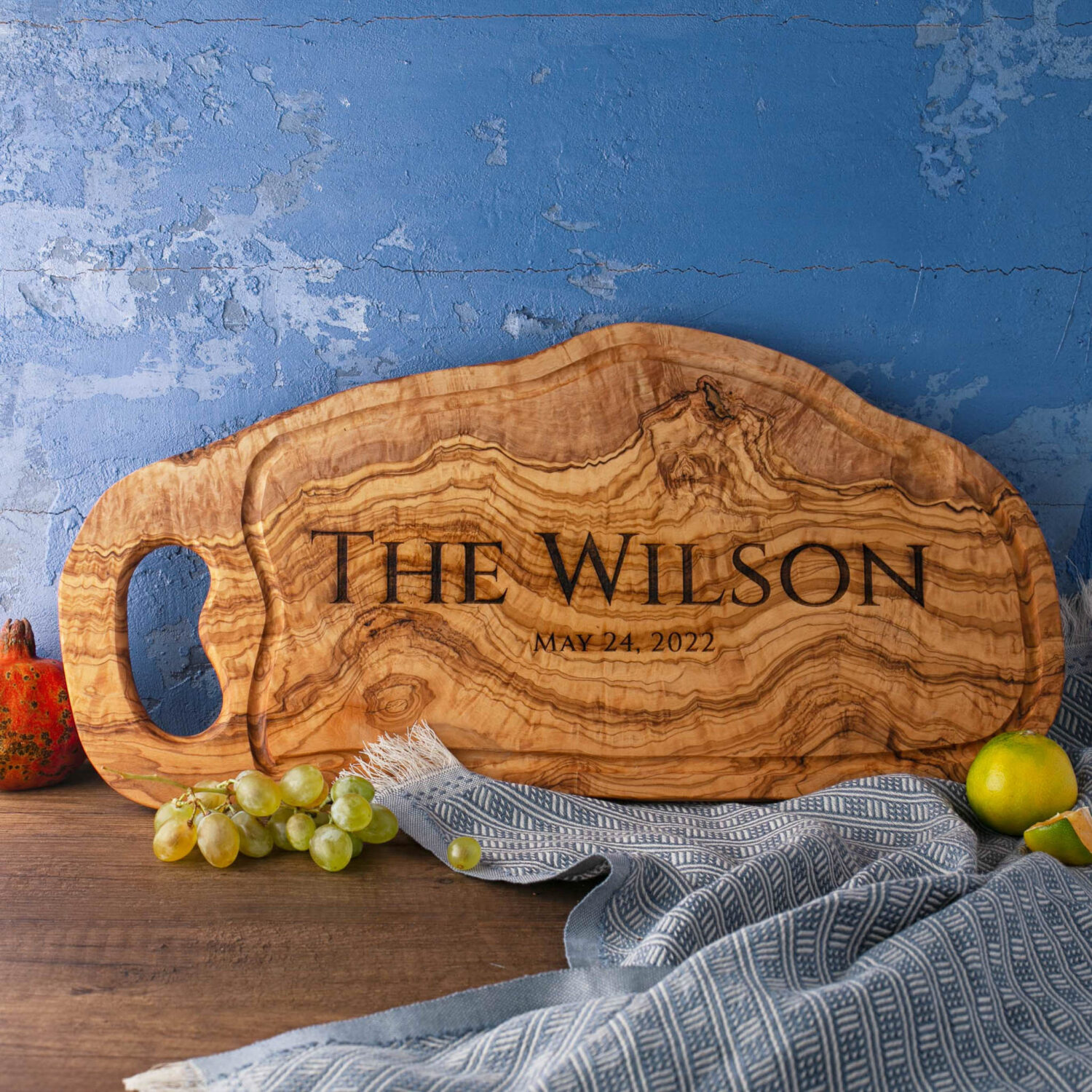 A BBQ Cutting Board Olive Wood with the name the Wilson on it.