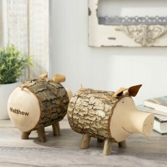 Two wooden pigs sitting on a wooden table.