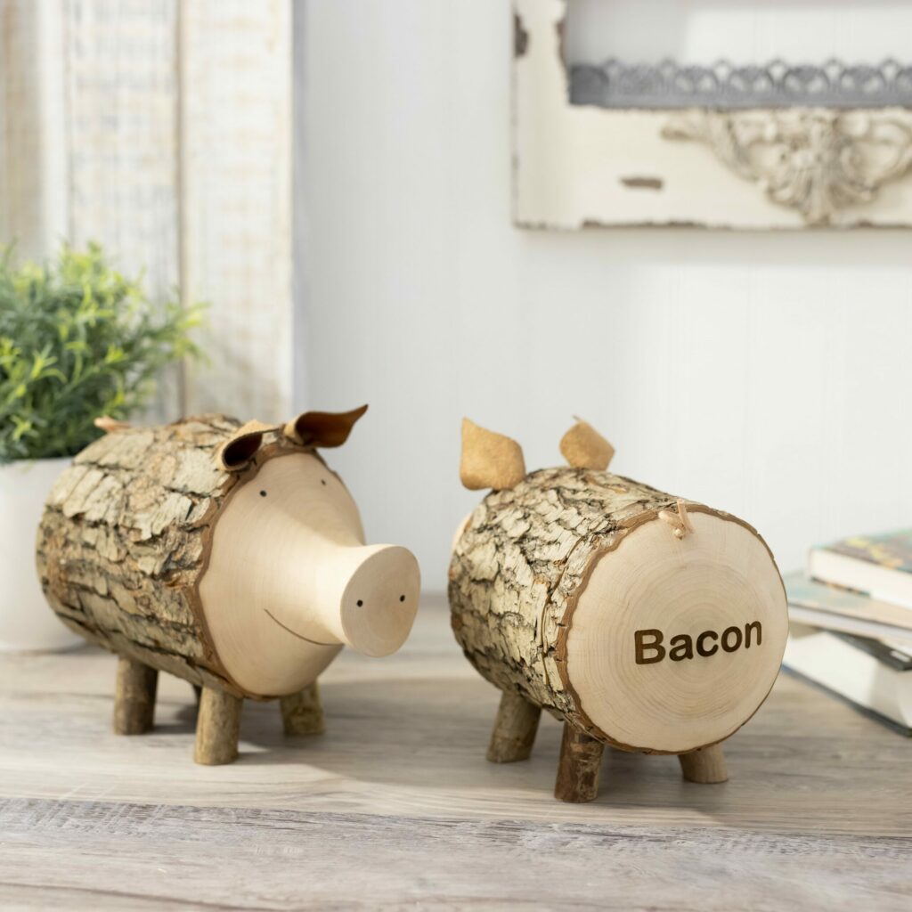 Two wooden pigs with the word bacon on them.