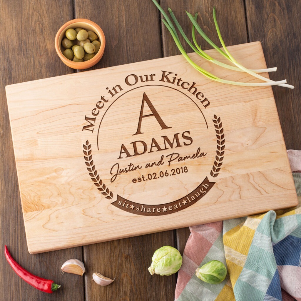A wooden cutting board with the words'meet in our kitchen'.