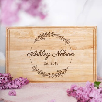 A wooden cutting board with the name abby nelson on it.