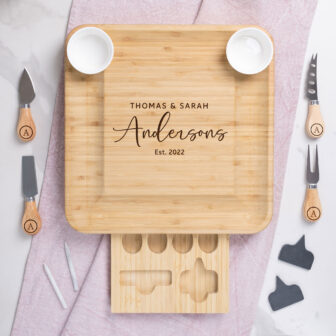 Personalized wooden cutting board with cheese knives, labeled 