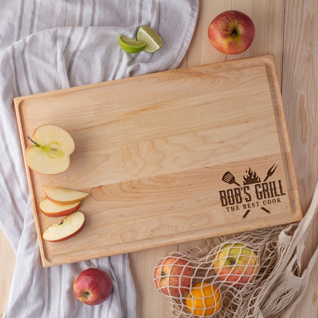 A wooden cutting board with apples and a bag of apples.