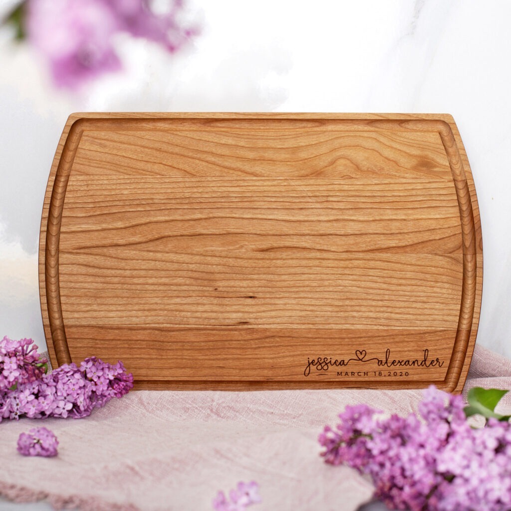 A wooden cutting board with lilac flowers on it.