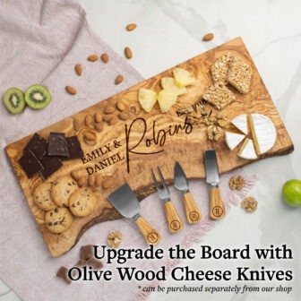 An engraved wooden cheese board featuring a selection of snacks and a set of olive wood cheese knives, advertised as an upgrade option.