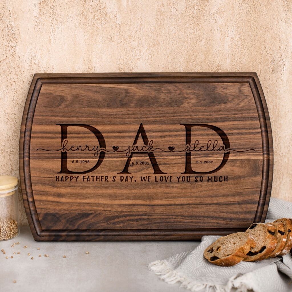 A wooden cutting board with the word dad on it.