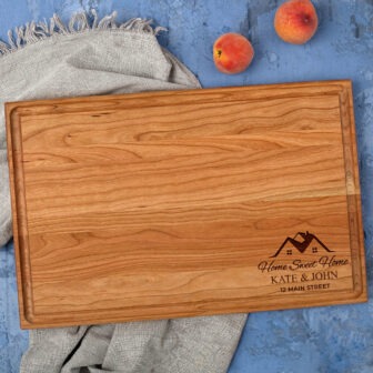 A wooden cutting board with a peach on it.