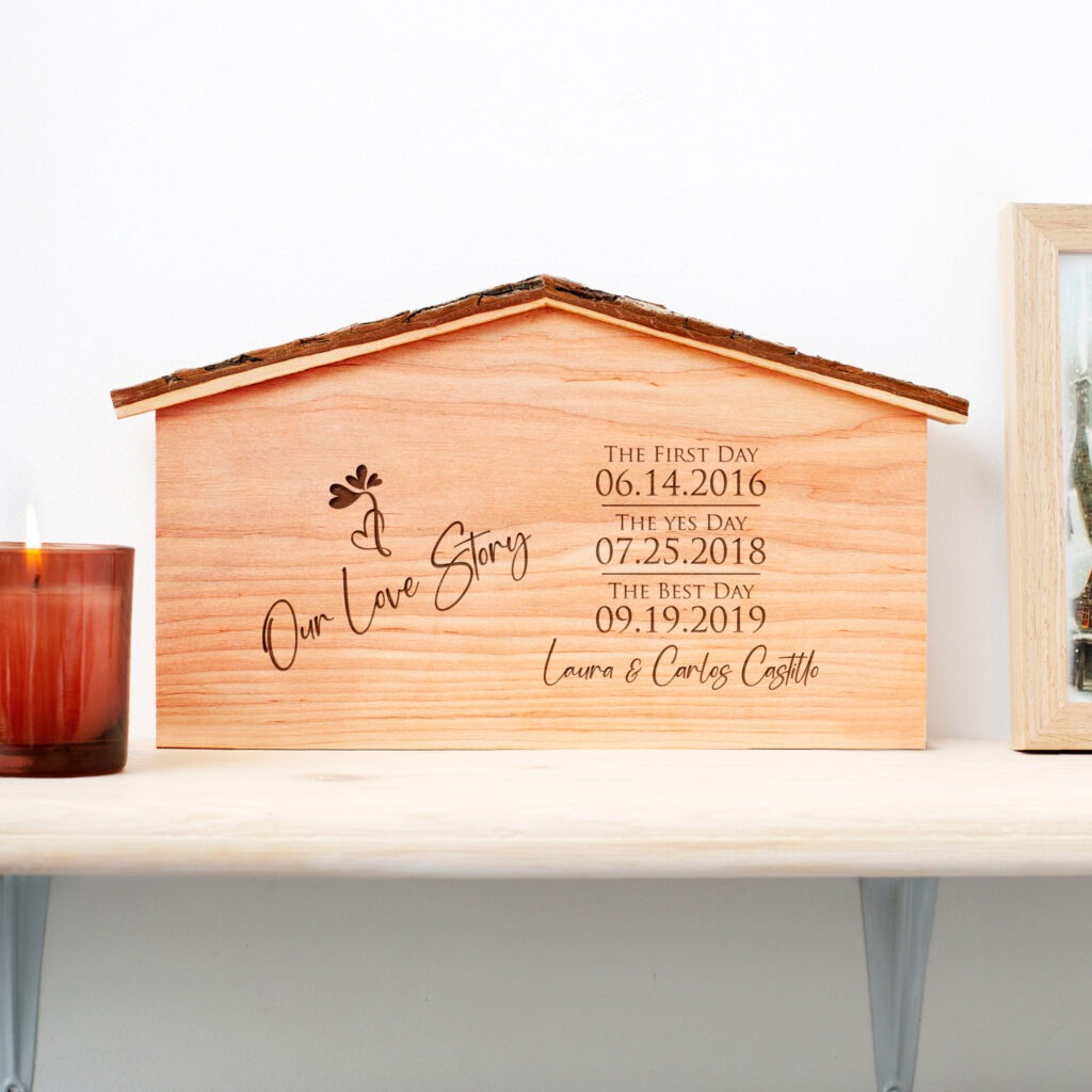 A wooden box with a candle and a picture of a house.