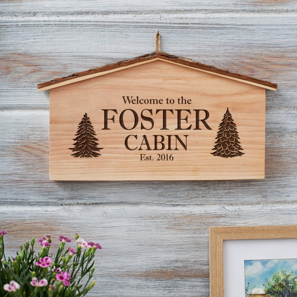 A wooden sign that says welcome to the foster cabin.
