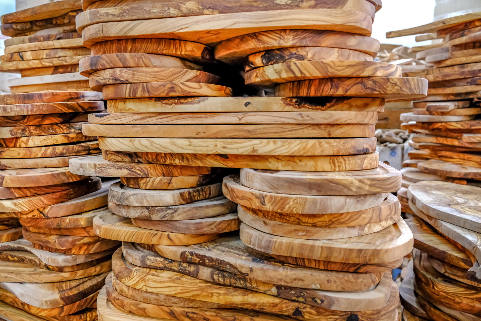 A stack of wooden cutting boards in a market.