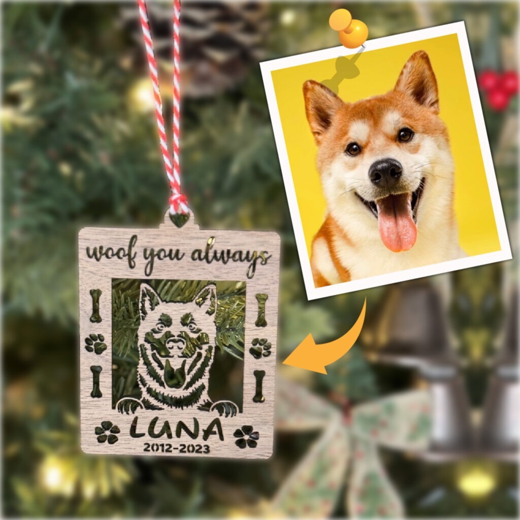 A photo of a dog hanging on a christmas tree ornament.
