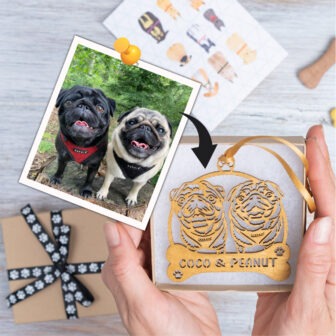 A person holding a gift with a photo of a pug and a photo of a dog.