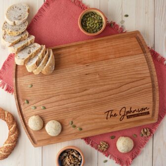 An engraved wood cutting board with bread on it.