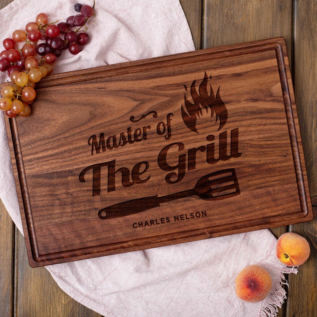 A wooden cutting board with the words master of the grill.