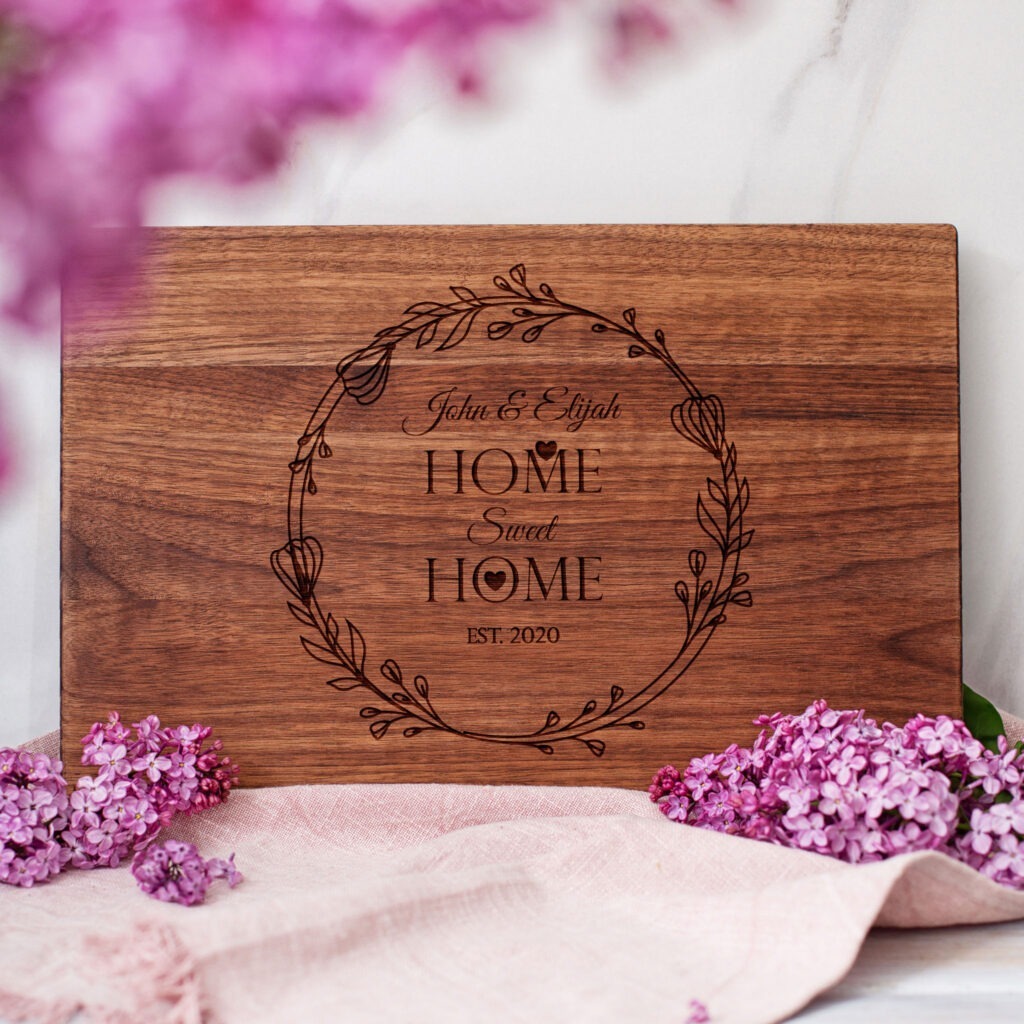 A wooden cutting board with the words home is where the heart is.