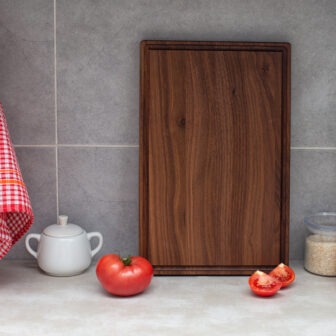 A Wood Cutting Board with Juice Groove (Walnut - 17x11) on a kitchen counter.