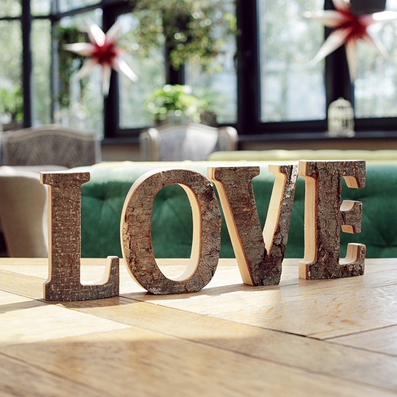 A wooden sign with the word love sitting on top of a table.