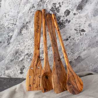 Four personalized olive wood spoon are sitting on a table.