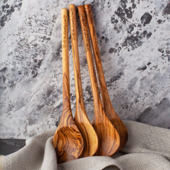 Three Engraved Wood Spoons sitting on top of a towel.