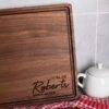 Custom walnut cutting board with personalized name.