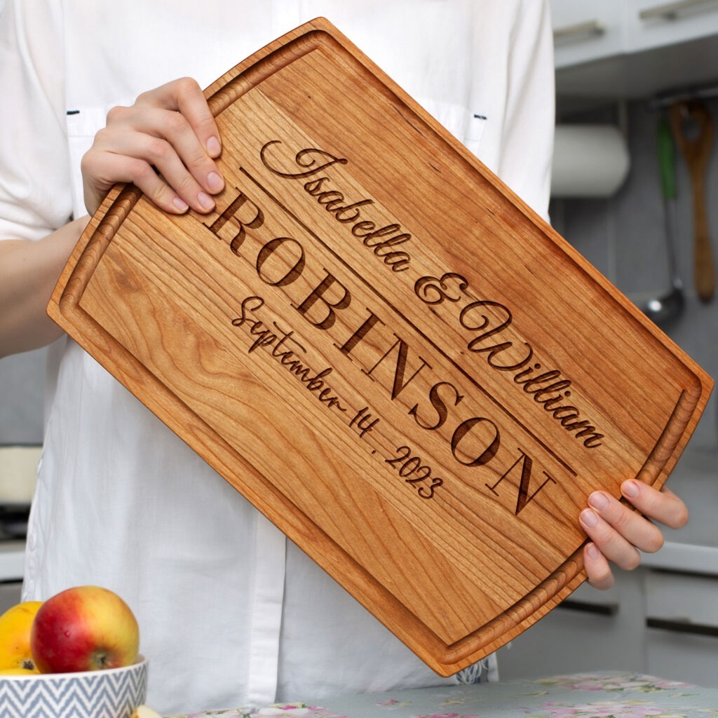A woman is holding up a wooden cutting board.