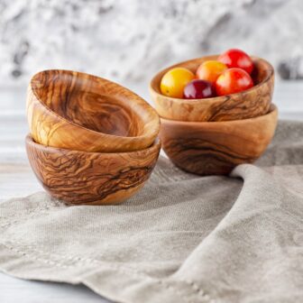 Three wooden bowls with fruit in them.