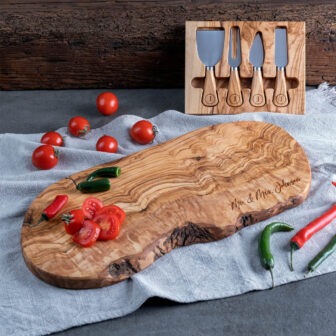 A wooden cutting board with a knife and peppers.