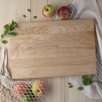 Homemade wood cutting boards with apples and a bag of apples.