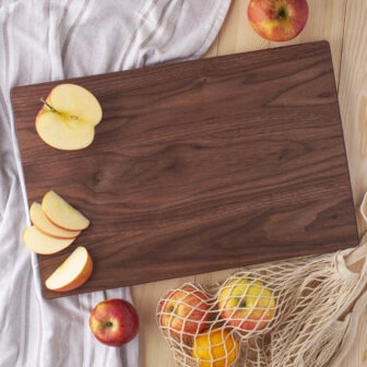 A Wood Cutting Board (Walnut) with apples on it.