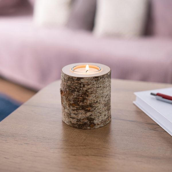 Birch bark tea light holder with a lit candle on a coffee table