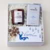Cozy Christmas gift box with a candle, hot cocoa and snowflake ornament