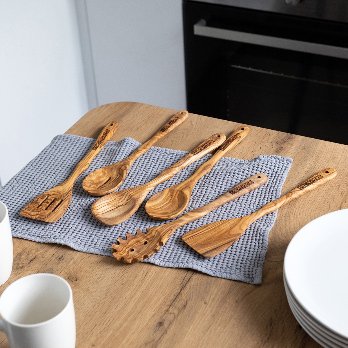 Olive wood utensil set with a company logo engraved on each handle
