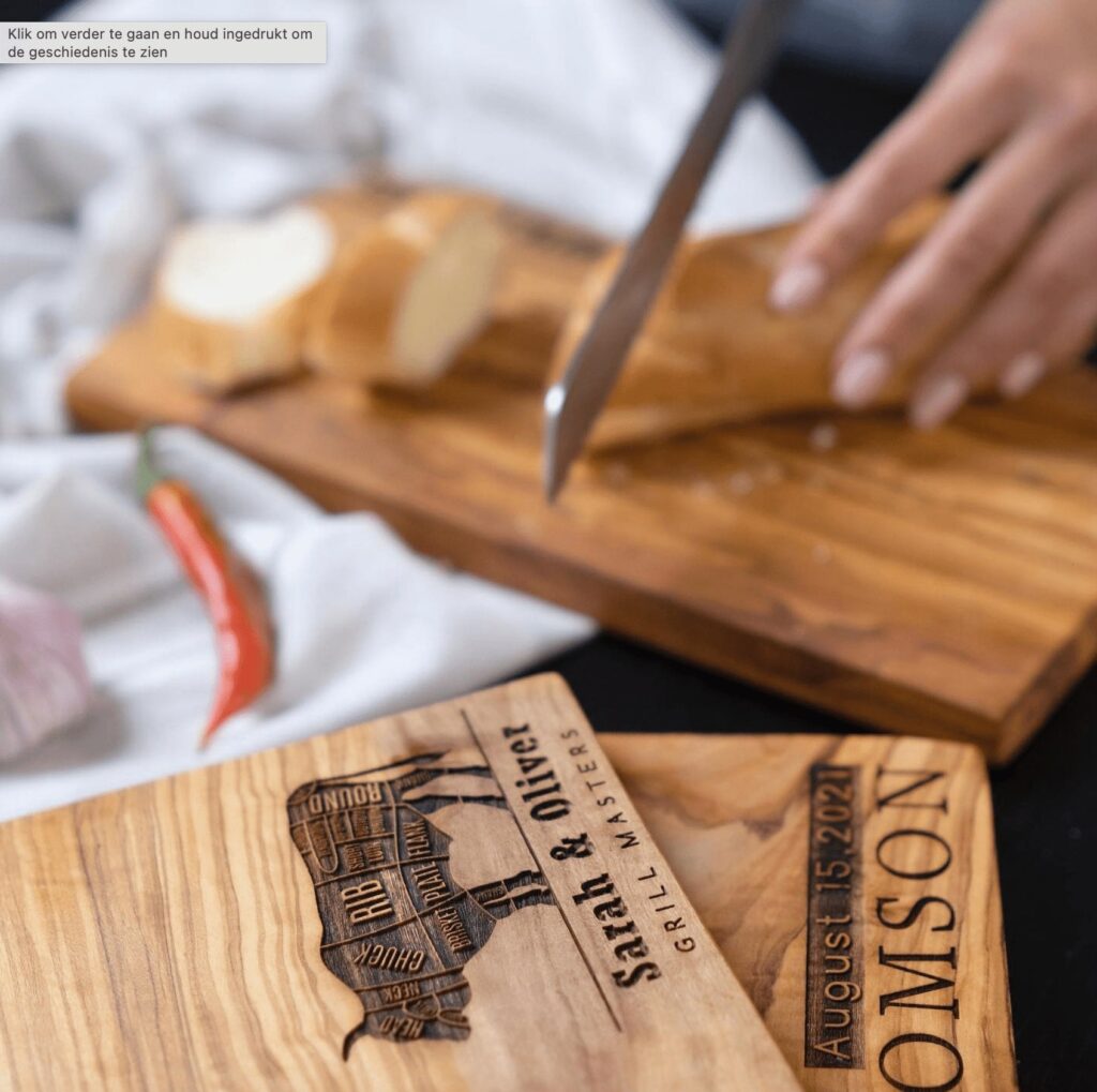 Person slicing bread on a wooden cutting board with engraved text "august 15, 2021, johnson." a chili pepper and fabric are partially visible.