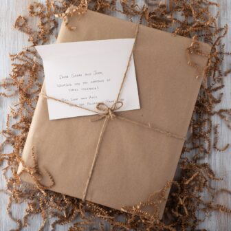 A gift wrapped in brown paper with a note inside.