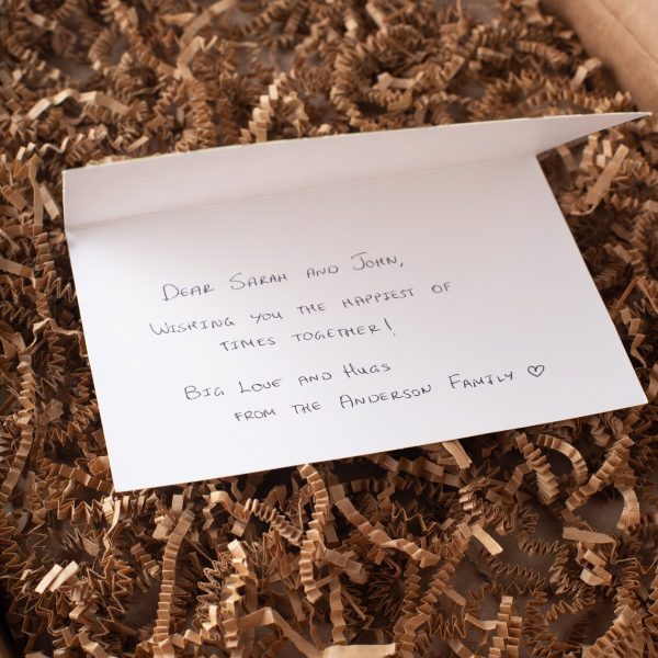 A note is sitting on top of a box of twigs.