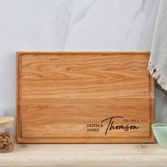 A wooden cutting board with the name thomas on it.