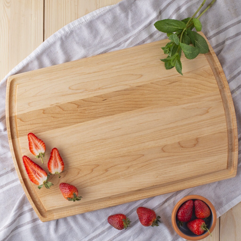A personalized serving board with strawberries on it.