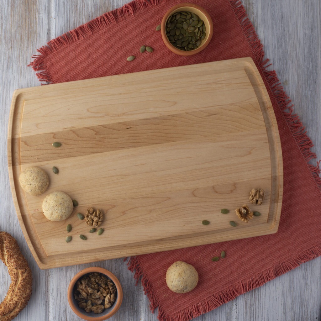 A custom engraved cutting board with nuts and seeds on it.