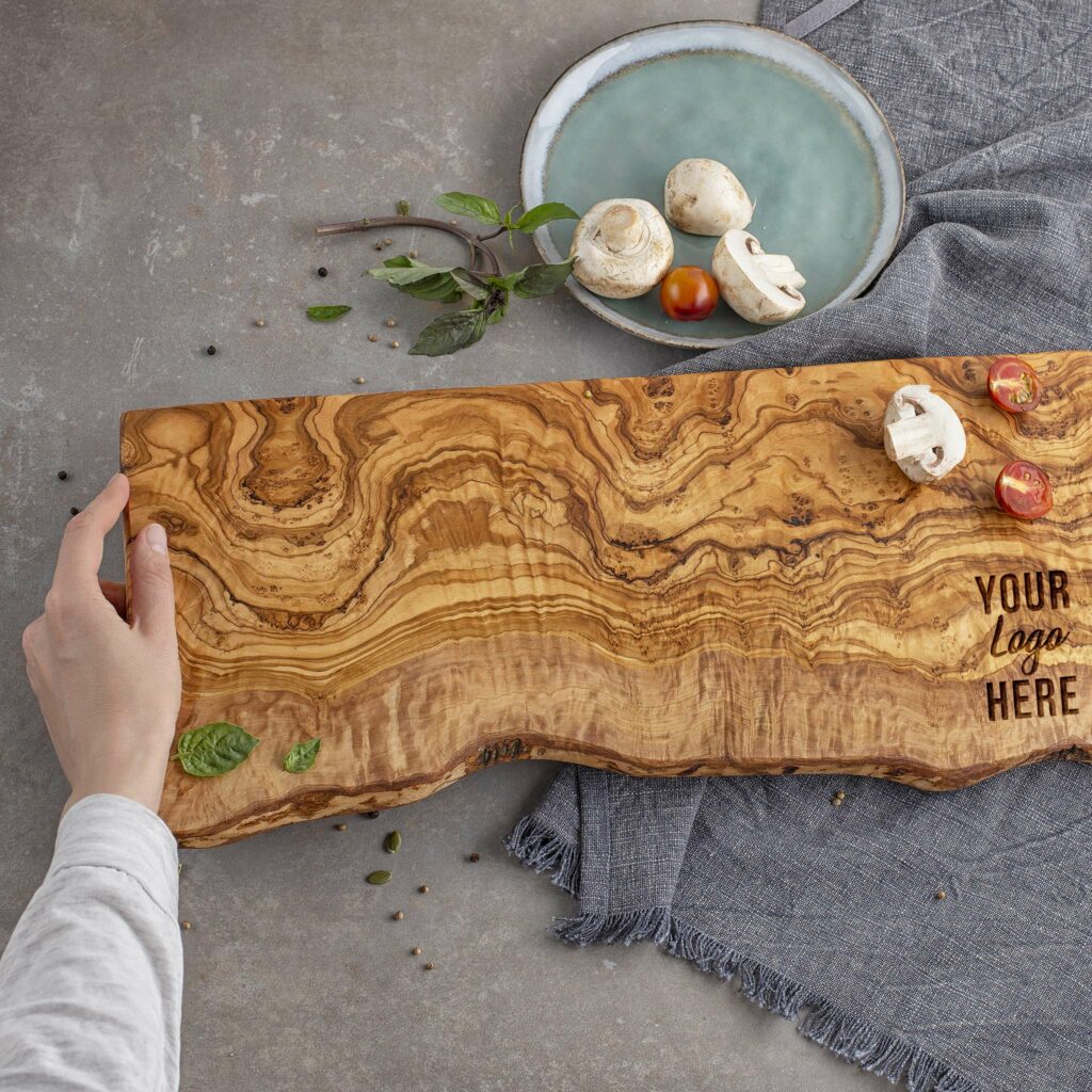A live edge olive wood charcuterie board with custom logo.
