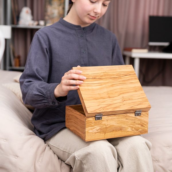 Woman opening an olive wood box with a hinged lid