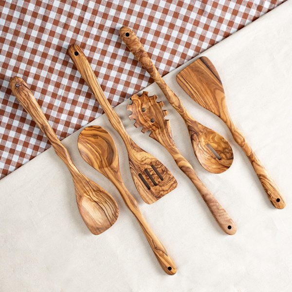 Six olive wood kitchen utensils on a checkered cloth