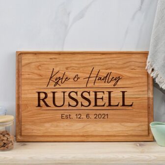 A wooden cutting board with the name kate and russell.