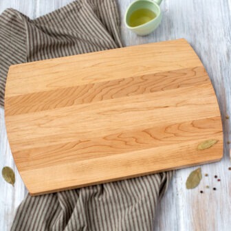 A wooden cutting board with herbs and spices on it.