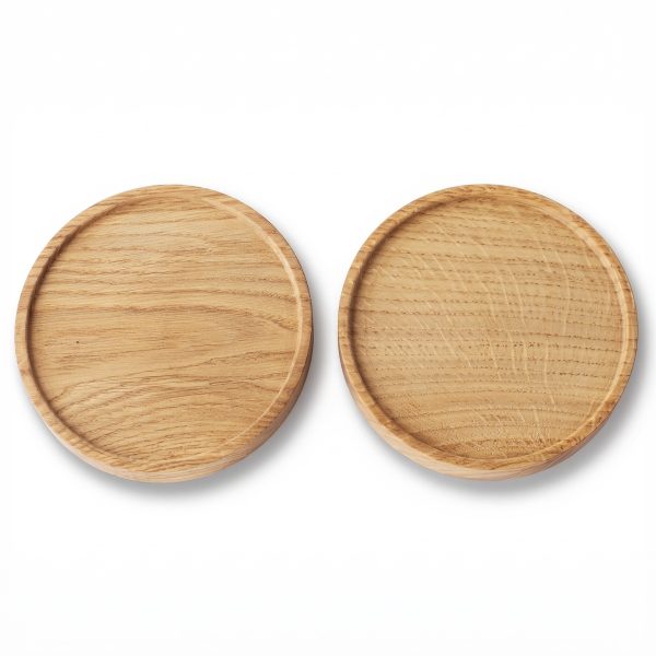 Two circular wooden coasters with a raised edge.