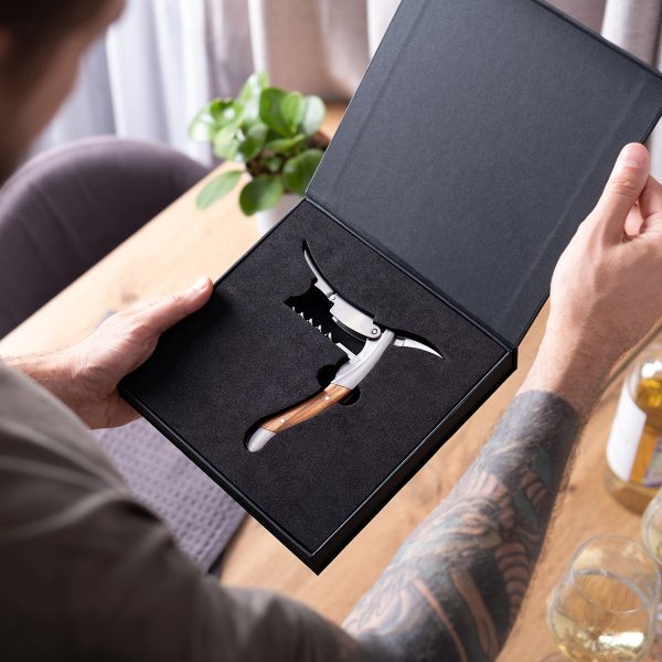Hands holding an open box with an olive wood corkscrew inside
