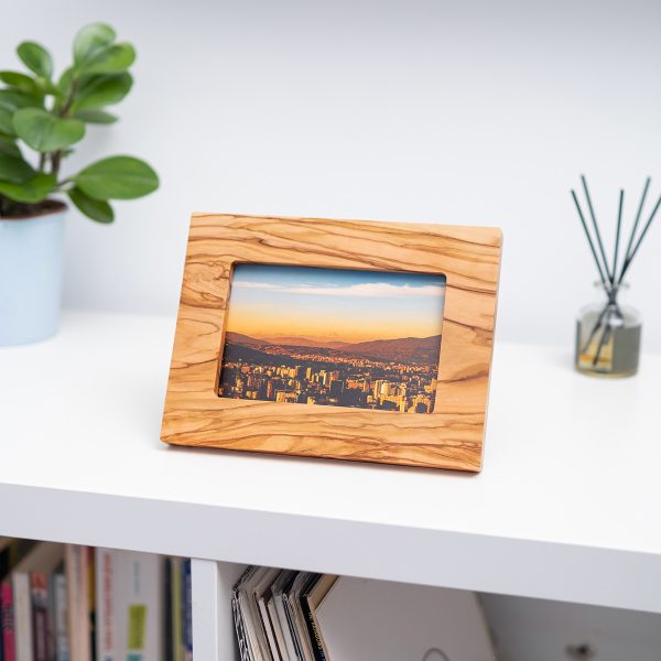 Olive wood picture frame turned sideways on a bookshelf